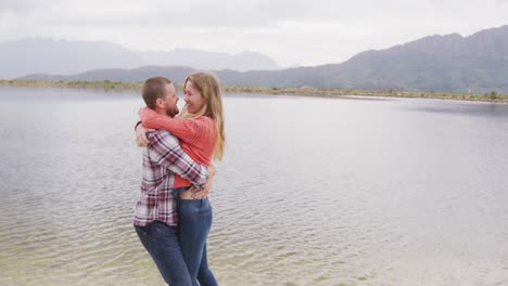 Caucasian-couple-having-a-good-time-on-a-trip-to-the-mountains,-embracing,-the-man-kissing-woman-for