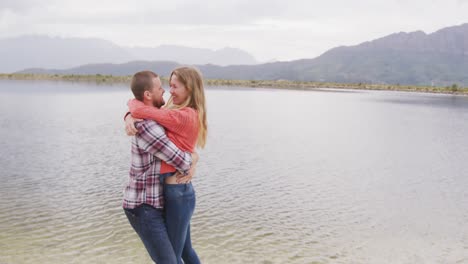 pareja caucásica pasando un buen rato en un viaje a las montañas, abrazándose, el hombre besando a la mujer para