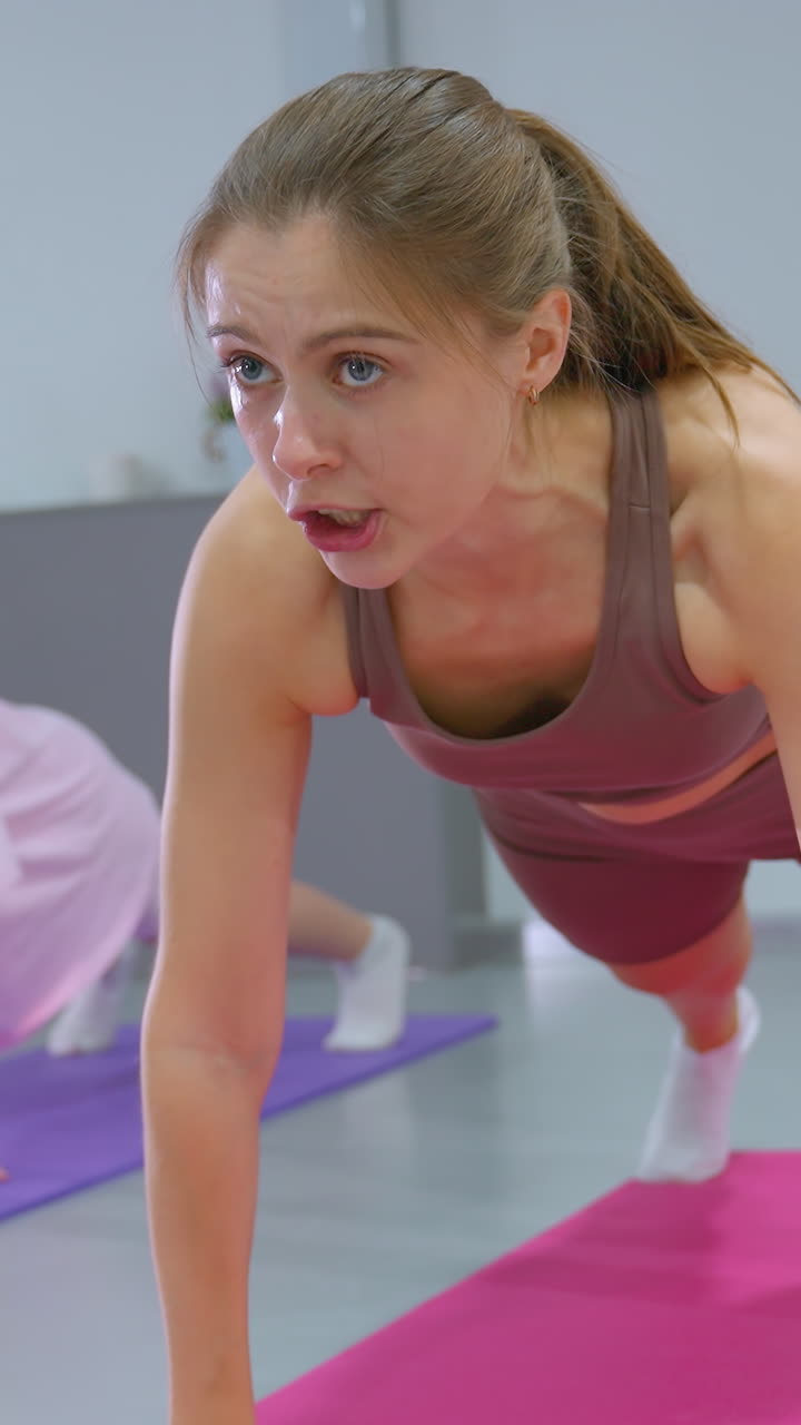 el entrenador de gimnasia demuestra un ejercicio de movimiento hacia atrás en la alfombra con las manos cerradas mientras el niño pequeño sigue su liderazgo, imitando cada movimiento con enfoque y determinación