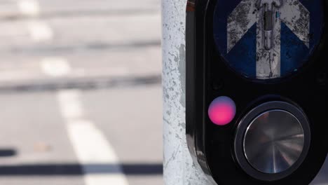 person pressing button at traffic light crossing