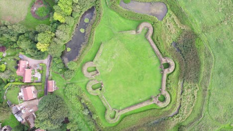 Aerial-video-footage-of-the-remains-of-Bolingbroke-Castle-a-13th-century-hexagonal-castle,-birthplace-of-the-future-King-Henry-IV,-with-adjacent-earthwork