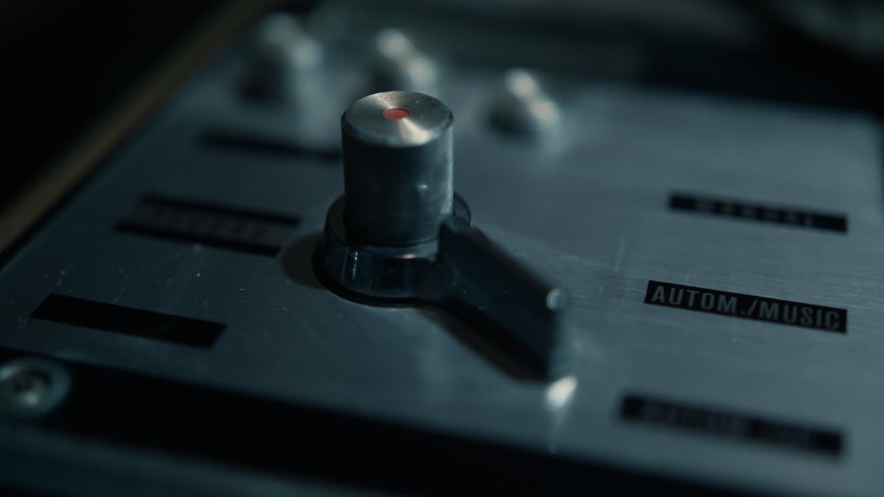Hånd justerer kontakt på lydmixerens kontrolpanel