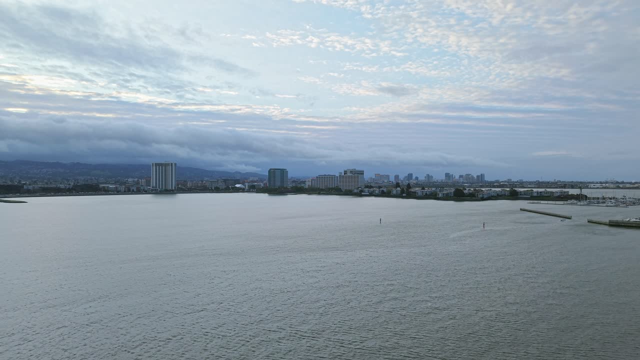 Emeryville’s shoreline glows with calm energy, where the waterfront merges with parks and distant buildings.