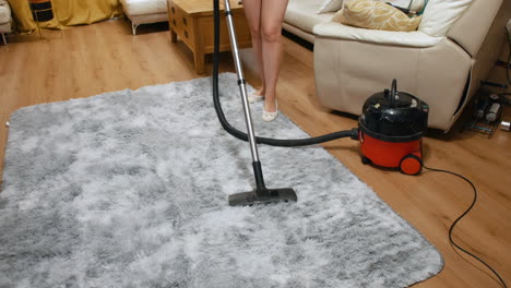 a woman using a vacuum cleaner to vacuum a rug