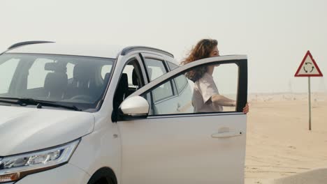 woman near a white suv in a desert landscape