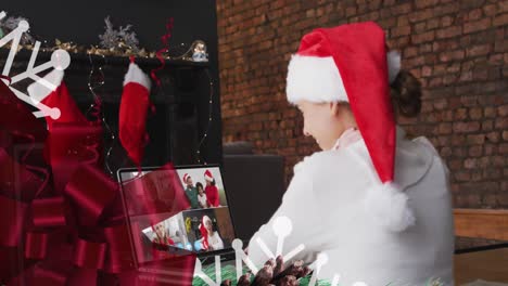 animación de decoraciones de navidad sobre feliz mujer caucásica en sombrero de santa en videollamada con la familia