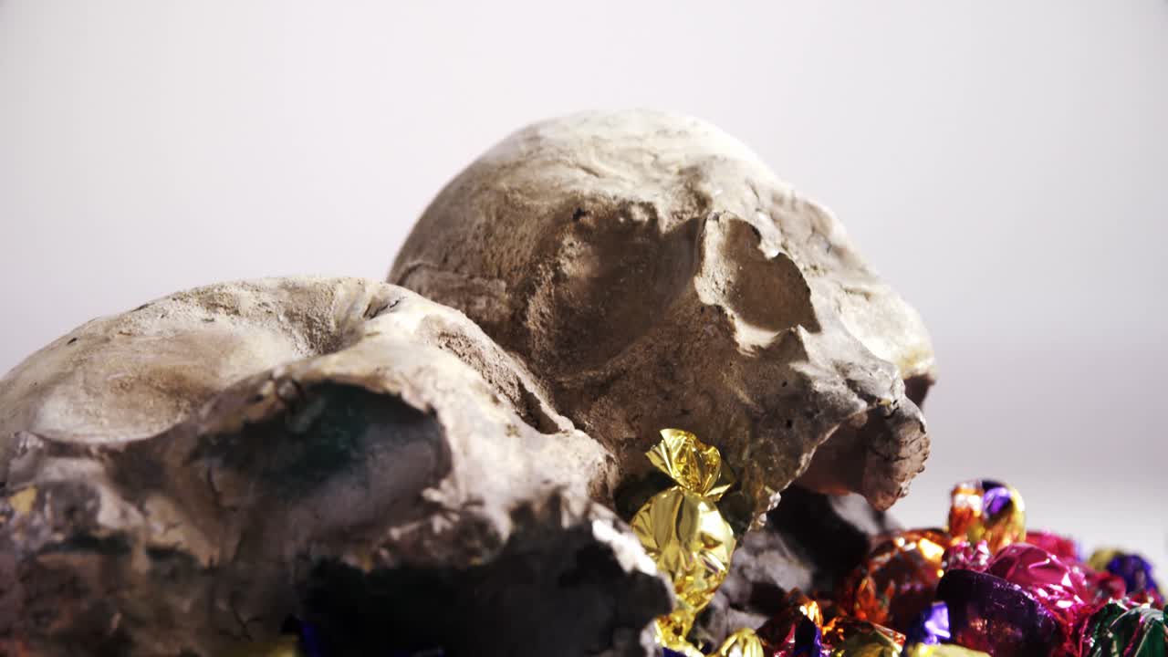 cráneo y varios dulces contra un fondo blanco 4k