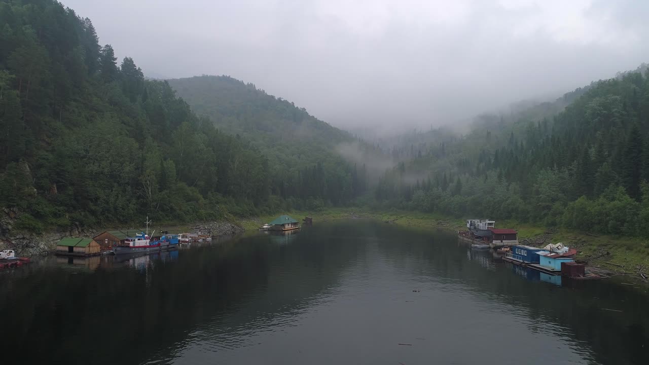 vista aérea de un lago en el bosque con niebla