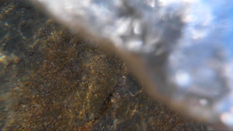 POV-from-within-the-surf-being-buffeted-around-within-the-waves-surrounded-by-sand-and-bubbles-and-wave-froth