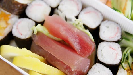 various sushi rolls with shrimp in plastic tray