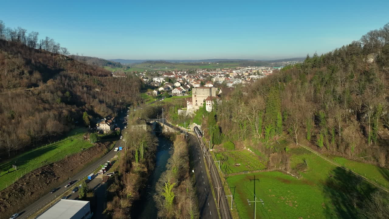 Beautiful historical Schloss Angenstein builded on a hill while a train is driving through the tunnel with a great view on the river Bird and city Aesch