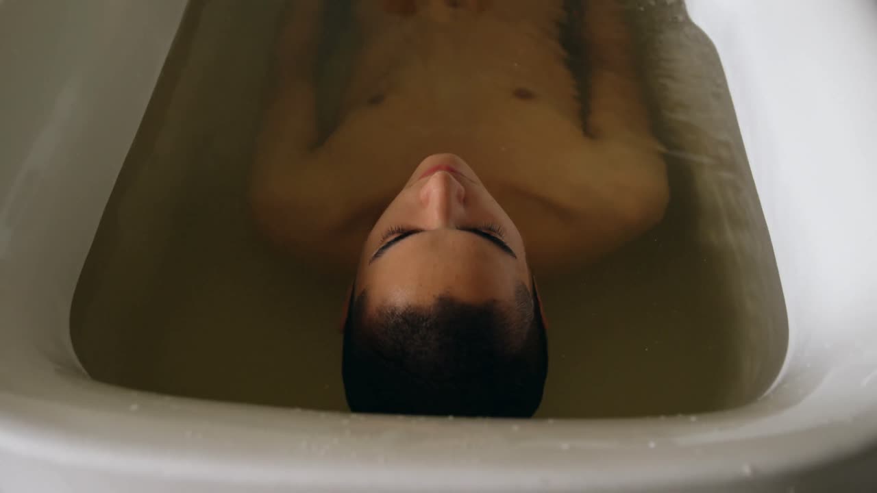욕실 4k에서 욕조에서 목욕하는 남자