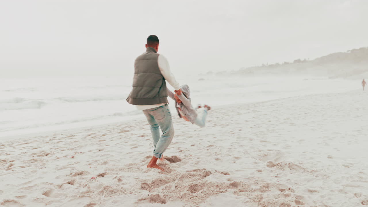 아버지와 딸이 해변에서 놀고 있다