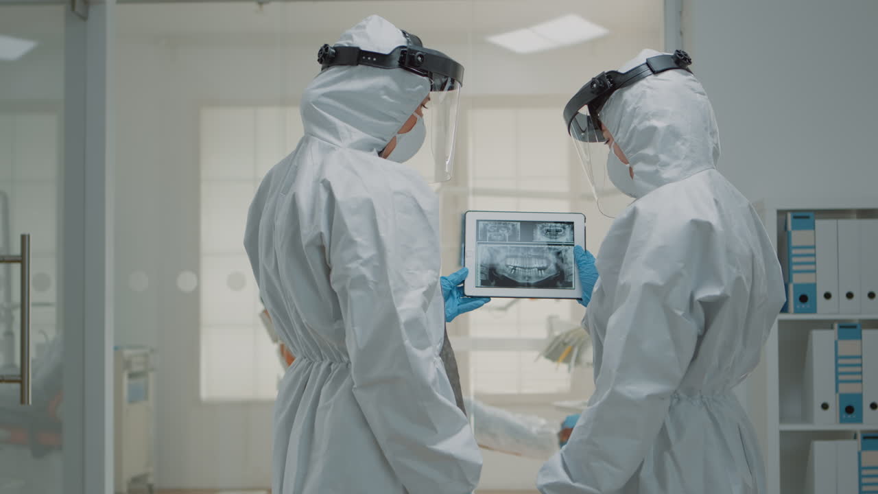 ortodontistas profesionales mirando rayos x dentales en una tableta digital