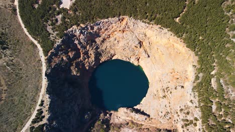 flying over the red lake containing a karst lake close to imotski, croatia