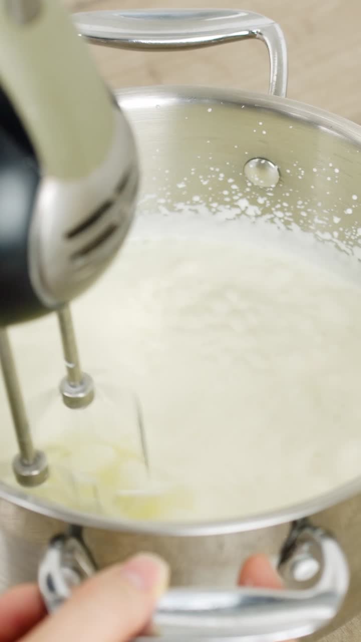 Vertical close-up of a hand mixer making a creamy mascarpone for tiramisu
