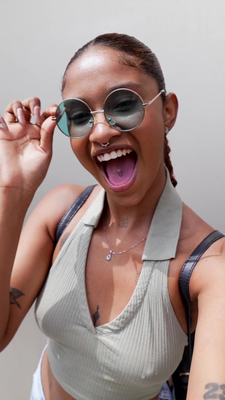 Playful Young Woman Posing and Blowing a Kiss in Sunglasses