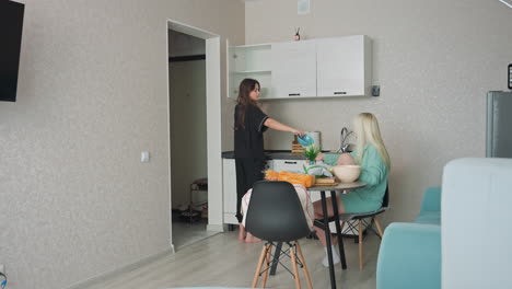 girl getting bowl from shelf to hand to sibling seated at table as they prepare for breakfast in cozy kitchen, vibrant colors, casual morning atmosphere with lighthearted family interaction