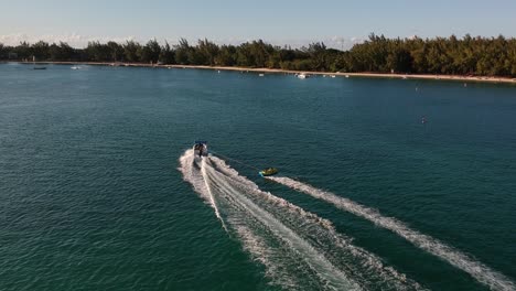 aerial shot of a sport boat pulling a big float with people on it