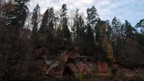 Angels-Cave,-a-Red-Sandstone-Cliff-in-a-Shape-of-Angel-Wings,-at-the-River-Salaca-in-Skanaiskalns-Nature-Park-in-Mazsalaca,-Latvia,-Autumn-Time