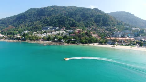 una lancha rápida arrastra un barco de plátano en el mar famosa playa destino turístico. playa de patong phuket, tailandia