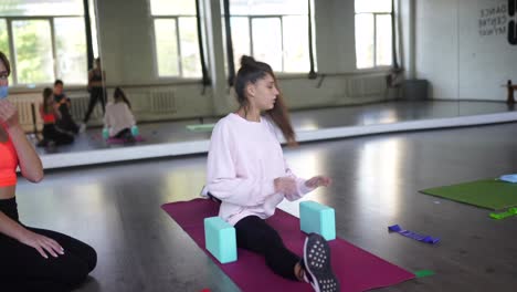 mujeres jóvenes estirándose en una clase de baile