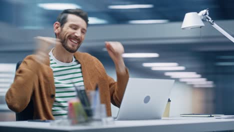 oficina moderna de 360 grados: hombre de negocios sentado en su escritorio trabaja en una computadora portátil, celebra el éxito. emprendedor digital que trabaja con una aplicación de comercio electrónico sonríe, feliz victoria.