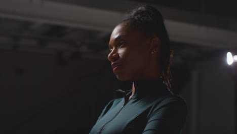 side view portrait of determined female athlete sport training in gym concentrating in changing room with focused expression