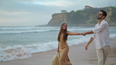 happy lovers walking sea beach outdoors. hispanic couple enjoying ocean coast