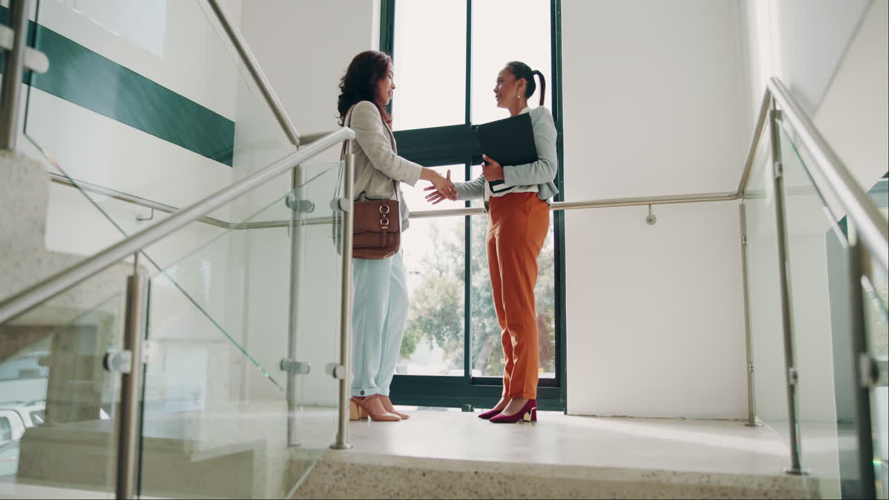 due donne d'affari che si stringono le mani in un ufficio moderno