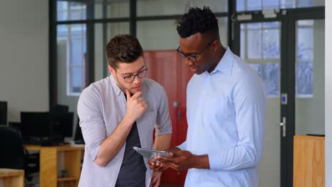 Front-view-of-young-mixed-race-business-team-working-on-digital-tablet-in-a-modern-office-4k