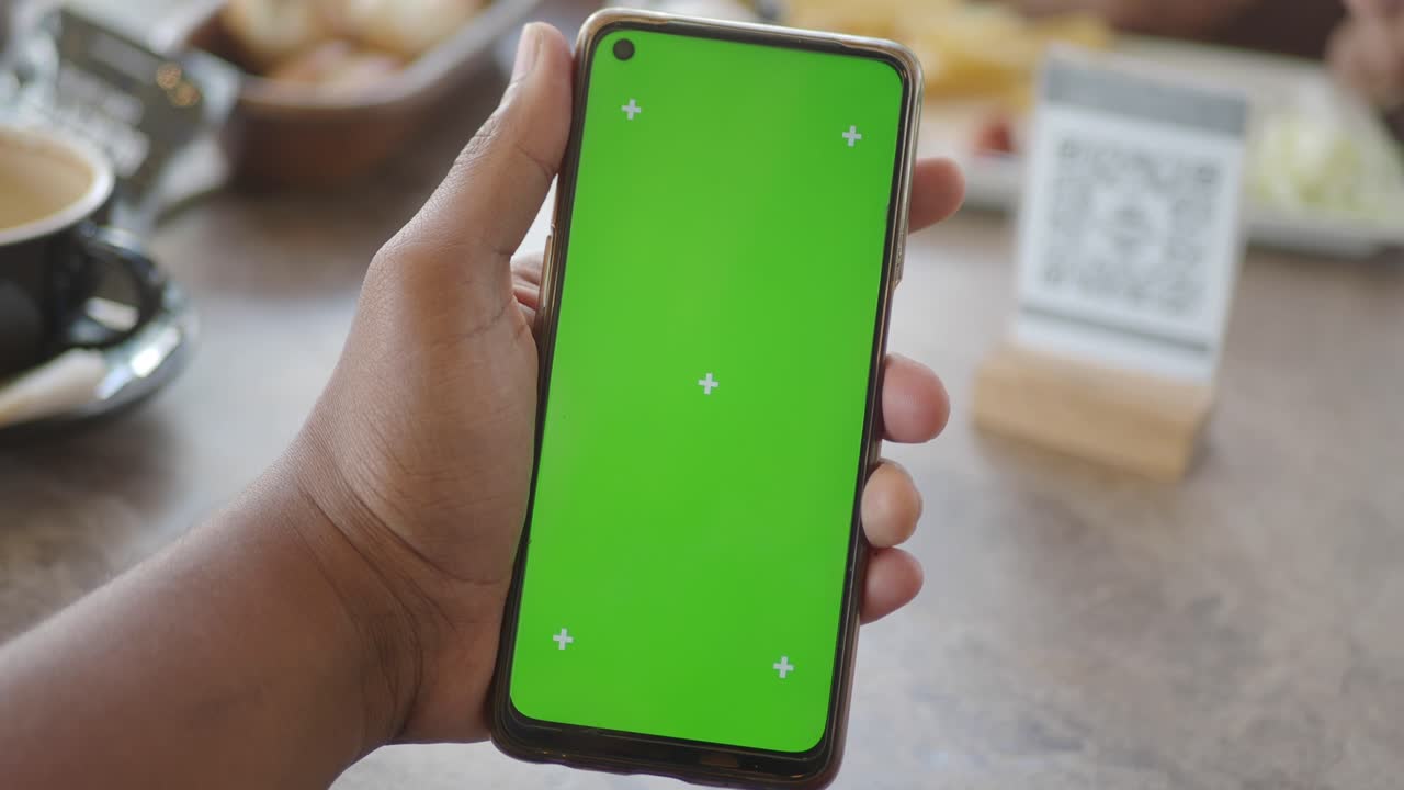 una persona con un teléfono de pantalla verde