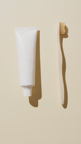 vertical video of toothpaste and toothbrush on beige background