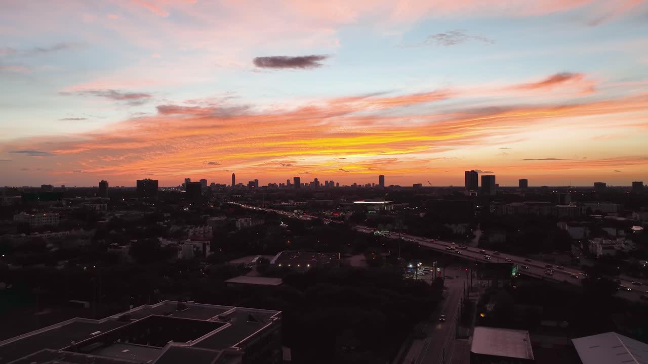 vista aérea de una autopista y el paisaje urbano con silueta de gran altura en houston, cielo colorido del atardecer en texas, ee.uu. - aumento, disparo de drones