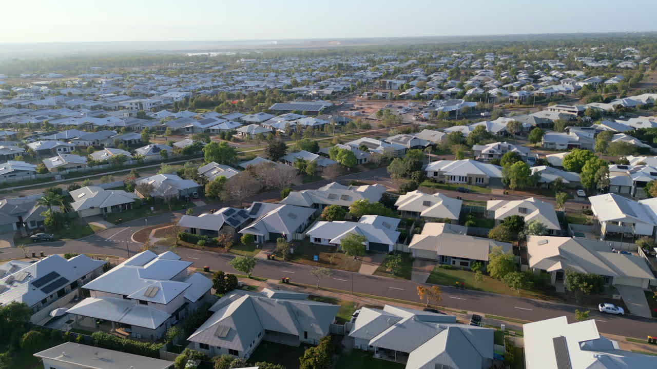 antena de drones volando sobre un barrio residencial, girando y bajando a una casa moderna en un día soleado