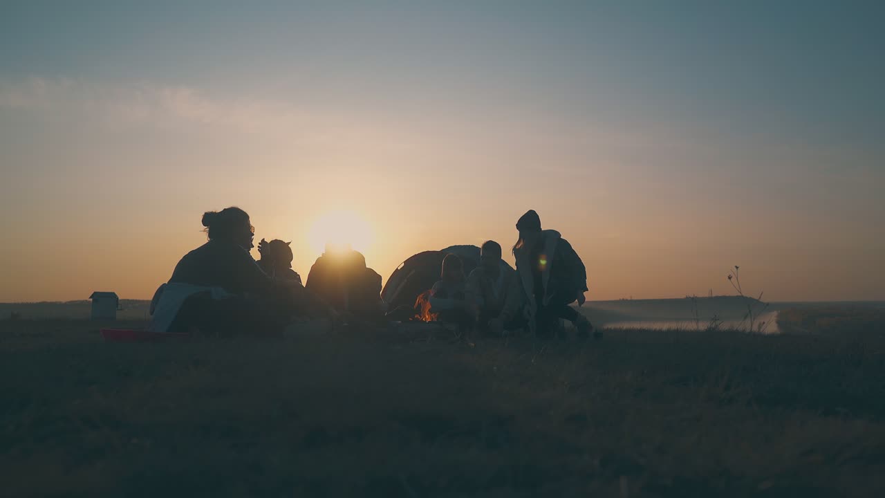 관광객 그룹 이 강변 에 있는 텐트 에 의해 불타는 불꽃 에 앉아 있다