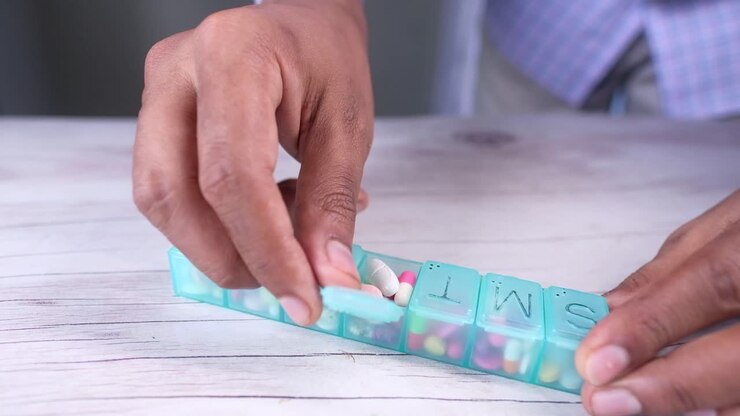 Person preparing weekly pill organizer