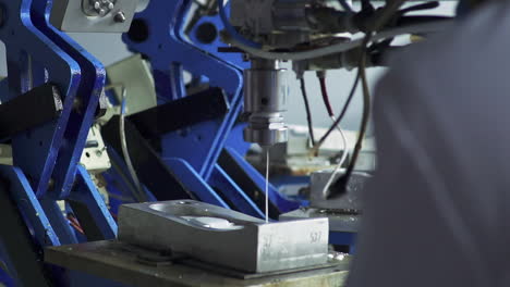 máquina industrial operativa para el vertido de líquido de poliuretano en una pieza de molde de acero de zapata en cámara lenta