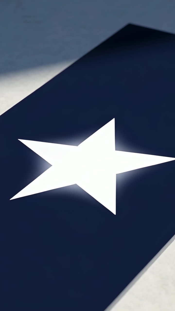Video verticale: Telecamera che si sposta facendo inclinare un pannello blu navy mentre un alone a stella si affievolisce su un tavolo grigio.