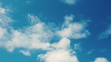 time lapse bright blue sky with white fluffy clouds floating by