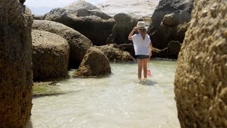 girl fishing with net at beach 4k