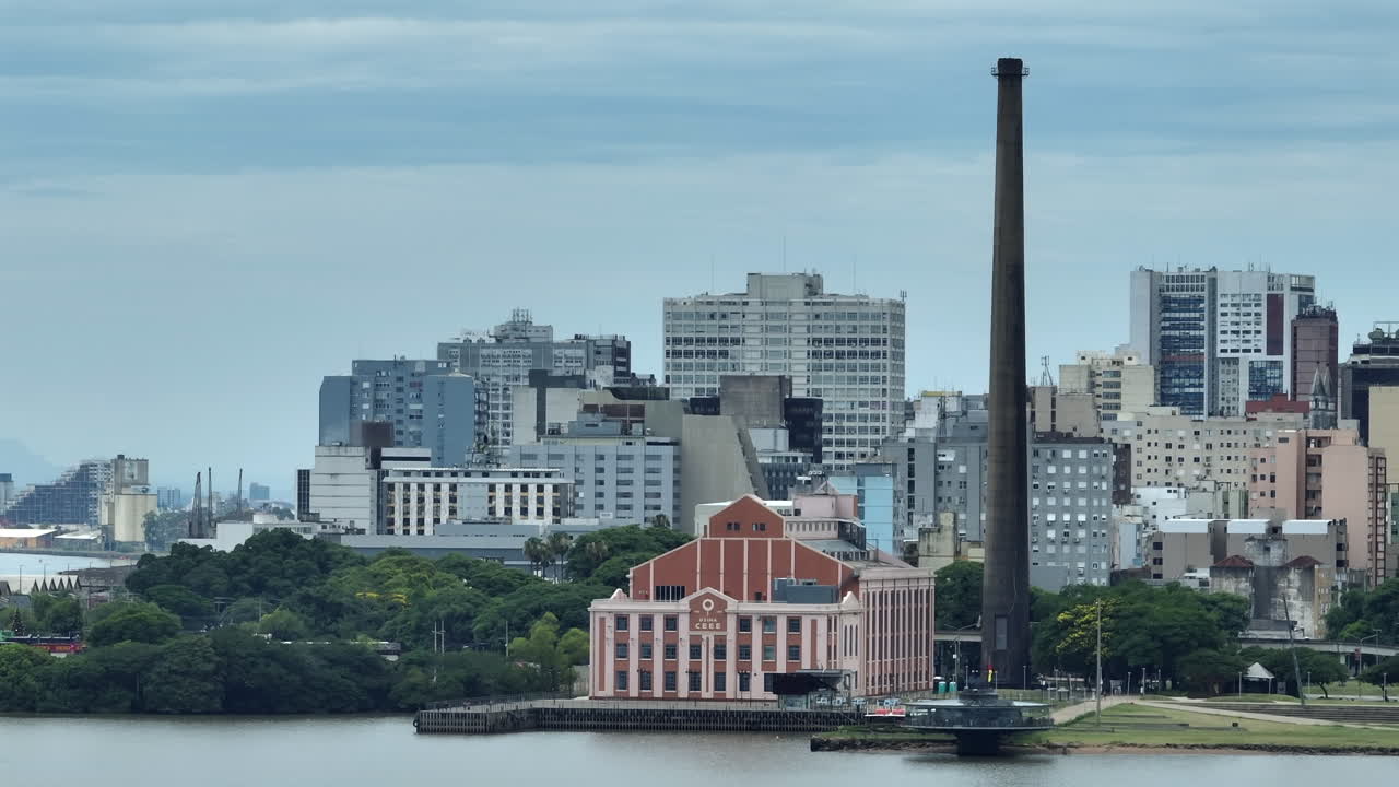 Usina do Gasometro y el perfil urbano de Porto Alegre captados en vista aérea con teleobjetivo 7x. Una toma general comprimida de la histórica central eléctrica y la densidad de la ciudad. Grabado en vídeo 4K profesional.