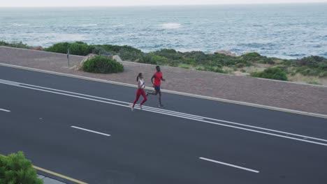 Pareja-Diversa-En-Forma-Haciendo-Ejercicio-Corriendo-En-Una-Carretera-Rural-En-La-Ladera-De-Una-Montaña