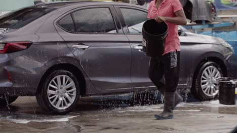 man washing a grey honda city car