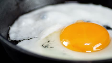 el huevo se fría en una sartén con burbujas de aceite.