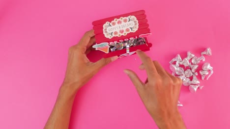 filling adorable miniature valentine's day kissing booth with candy