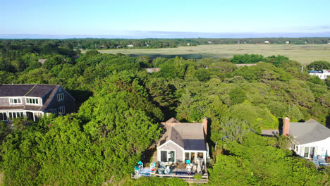 cape cod aerial drone footage of marsh and houses in forest surrounded by trees, lowering motion