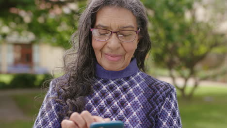 Retrato-De-Una-Mujer-India-Bastante-Anciana-Enviando-Mensajes-De-Texto-Navegando-Usando-Una-Aplicación-Para-Teléfonos-Inteligentes-En-El-Jardín-De-Una-Casa-De-Retiro