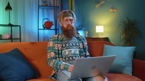 Bearded-redhead-man-use-laptop-surprised-by-bad-news,-fortune-loss,-fail,-lottery-results-at-home