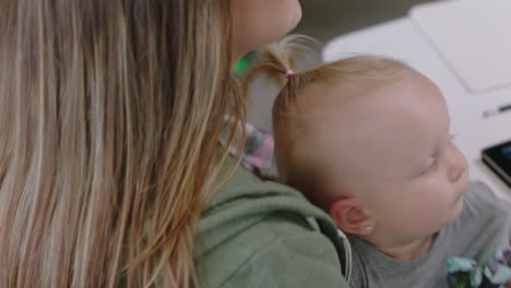 close up caucasian business woman mother holding baby discussing corporate project with colleagues multitasking in modern office workplace
